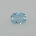 An oval-cut light blue faceted gemstone, centered on a plain light gray background.