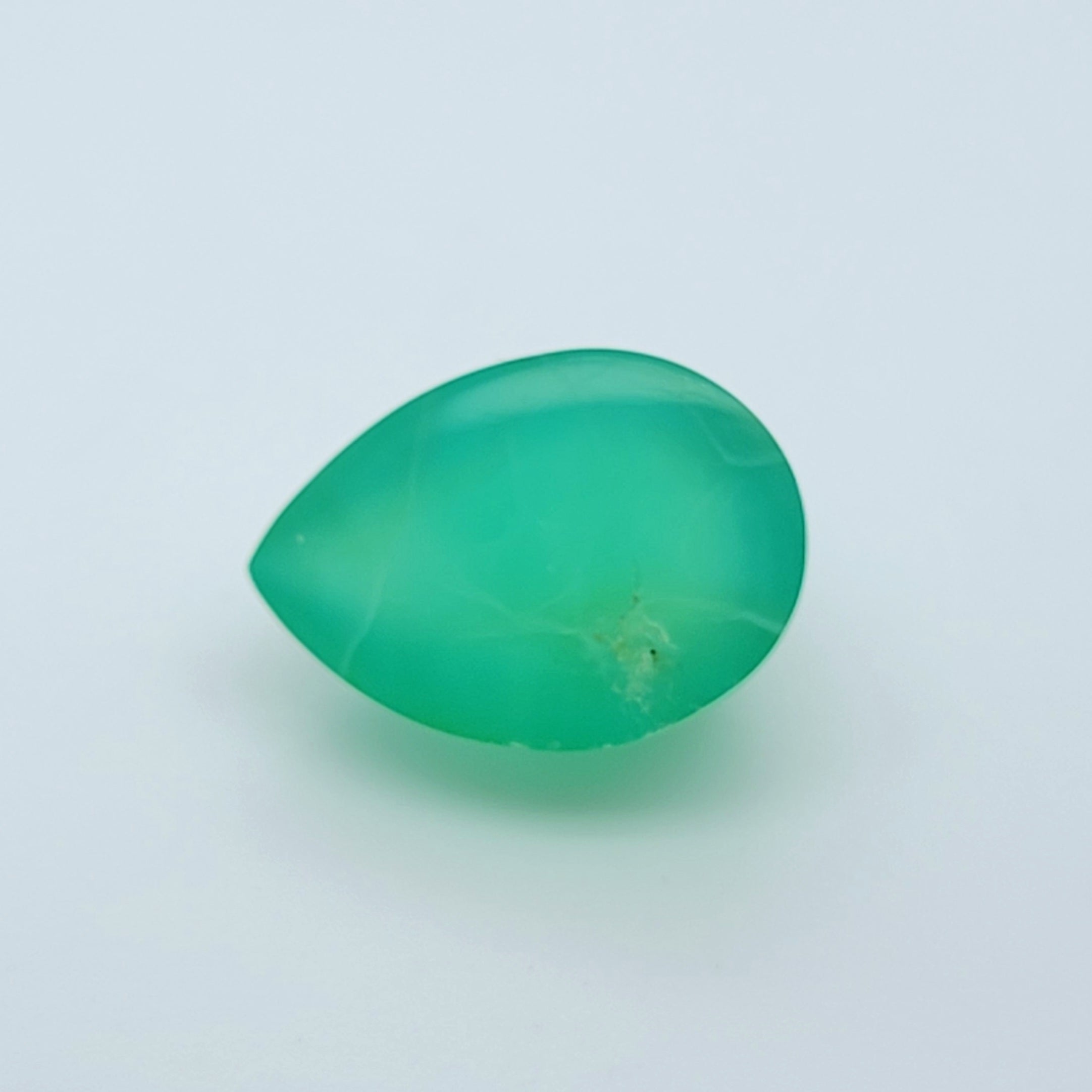 A polished, teardrop-shaped green gemstone cabochon on a plain white background.