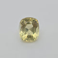 A cushion-cut yellow gemstone with a faceted cushion shape, displayed on a neutral light gray background.
