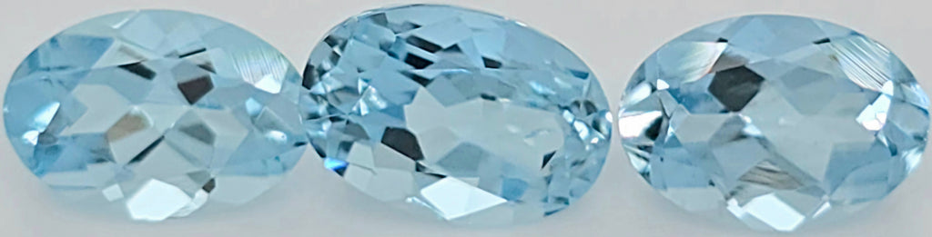 Three oval-cut light blue gemstones shown side by side on a plain white background.