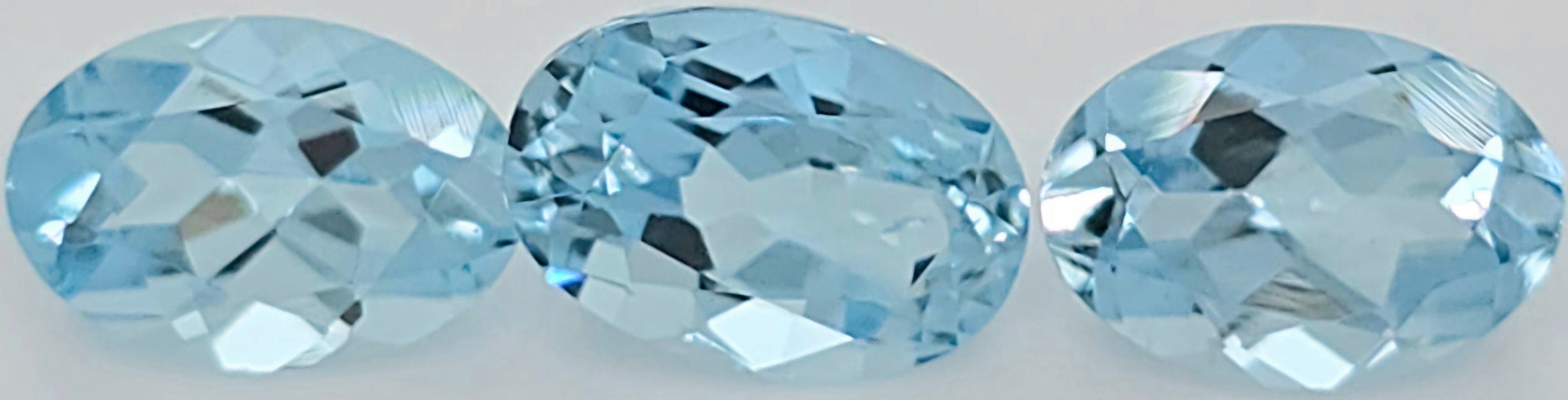 Three oval-cut light blue gemstones shown side by side on a plain white background.