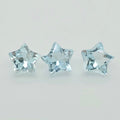 Three faceted light blue star-shaped gemstones arranged horizontally on a plain light gray background.