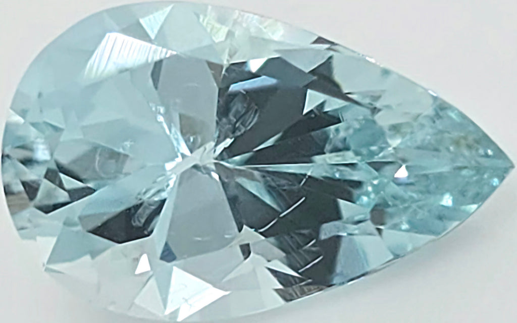A faceted pear-cut light blue gemstone, shown in close-up on a plain light background.