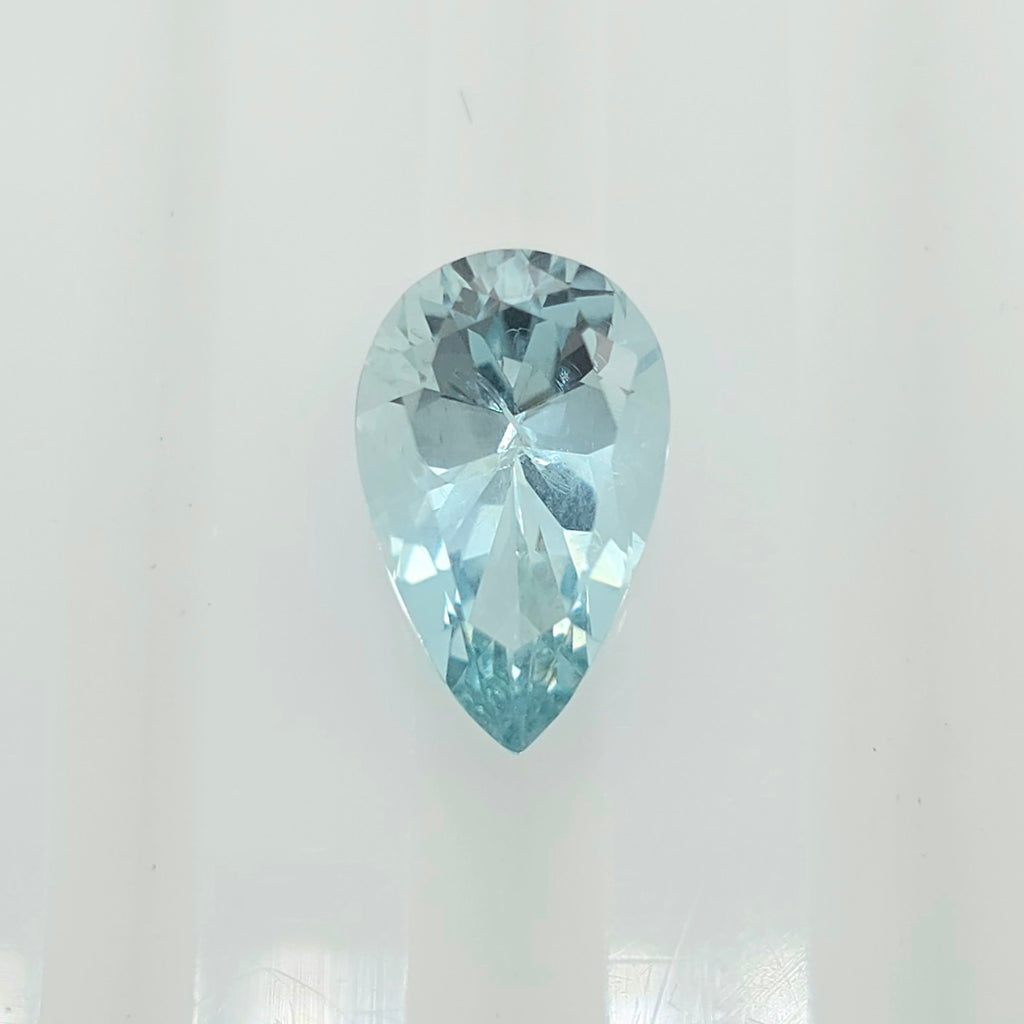 A single pear-cut light blue gemstone, centered on a plain white background.