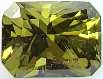 Faceted green gemstone on a white background