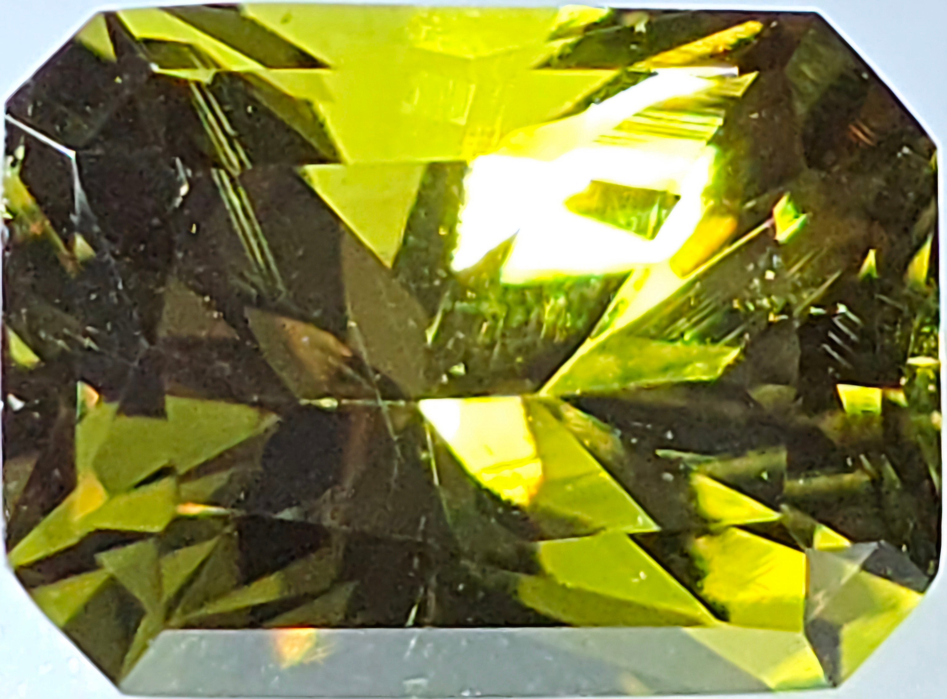 Faceted green gemstone on a white background