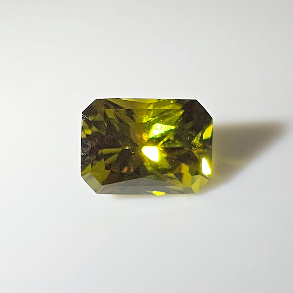 Faceted lime green gemstone on a white background