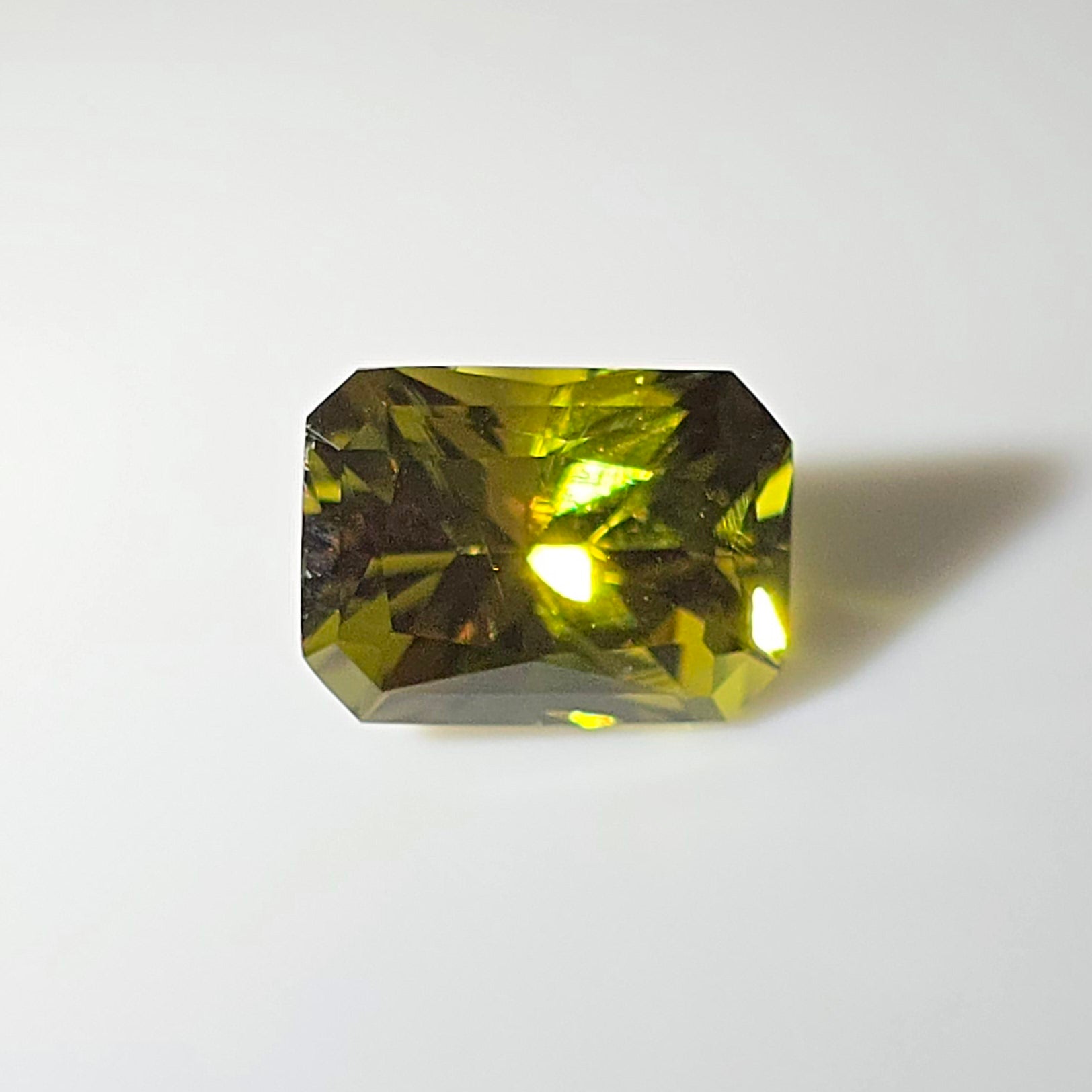 Faceted lime green gemstone on a white background