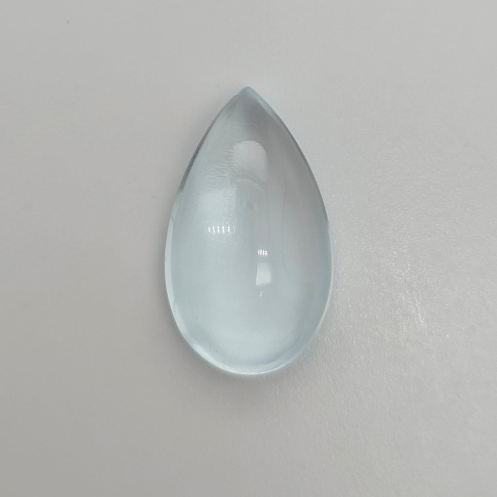 Pear shape light blue cabochon gemstone on a white background