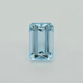 A single light blue emerald-cut gemstone centered on a plain light gray background.