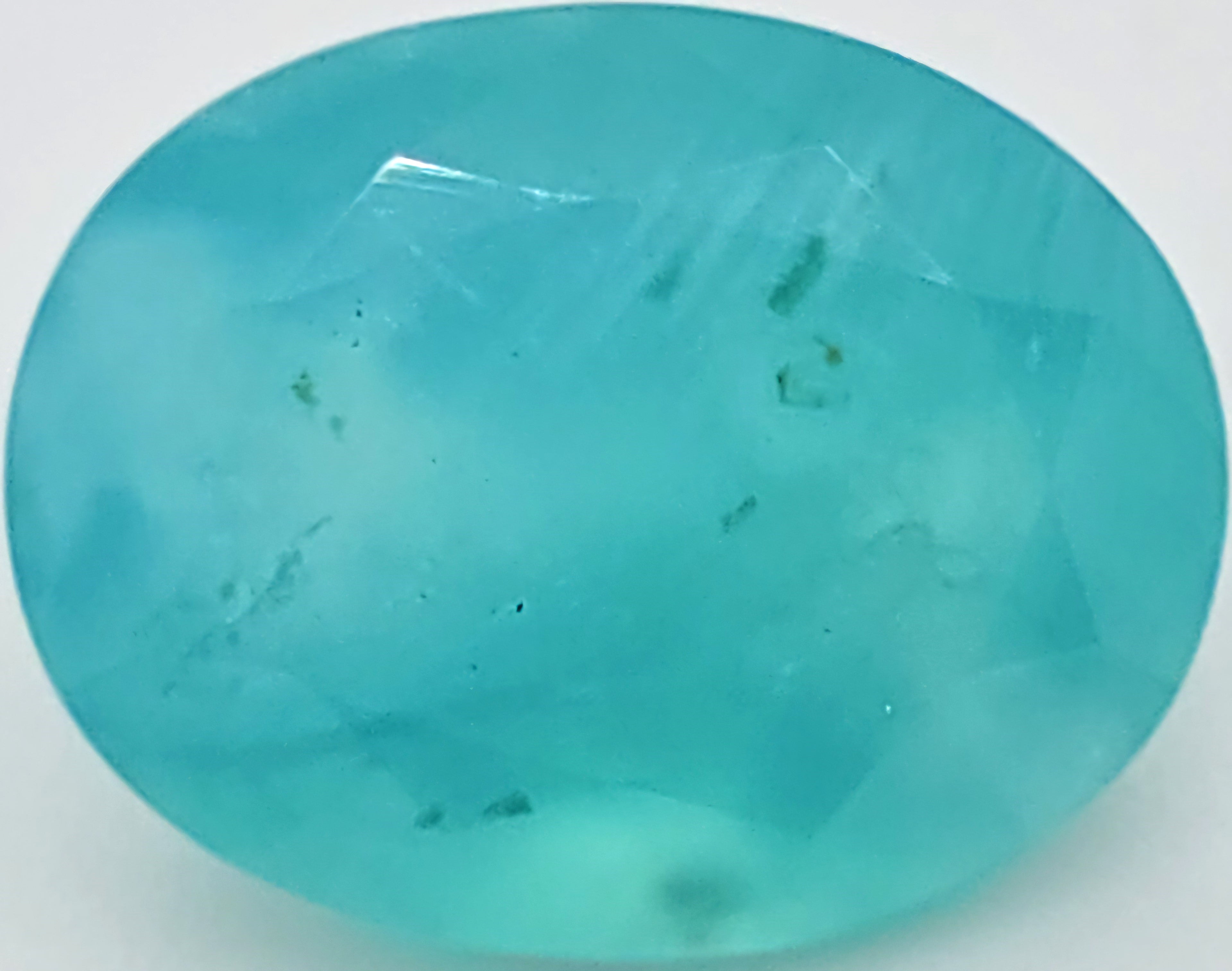 A faceted oval greenish blue gemstone with natural inclusions, shown on a plain white background.