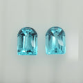 A pair of light blue faceted gemstone cabochons with a rounded top and rectangular body, displayed side-by-side on a plain light background.