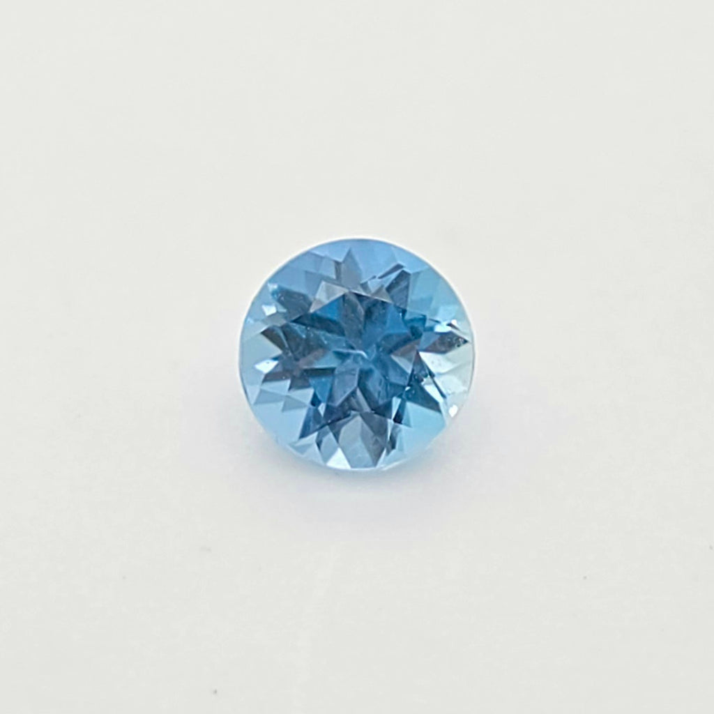 A single round-cut blue gem centered on a plain white background.