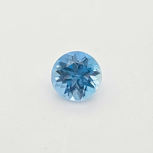A single round-cut blue gem centered on a plain white background.