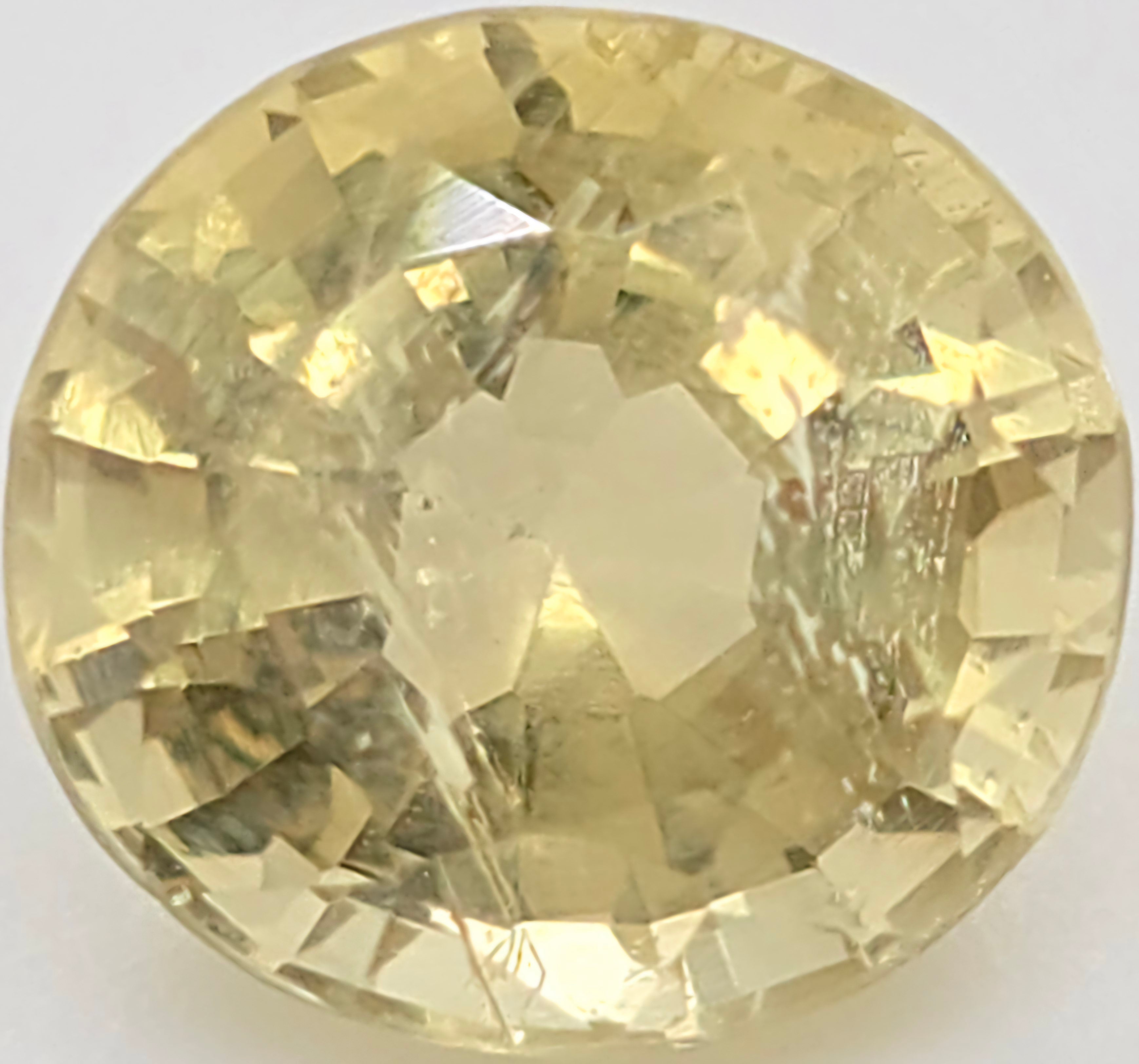 An oval faceted yellow gemstone, likely a shown in a top-down view against a plain white background.
