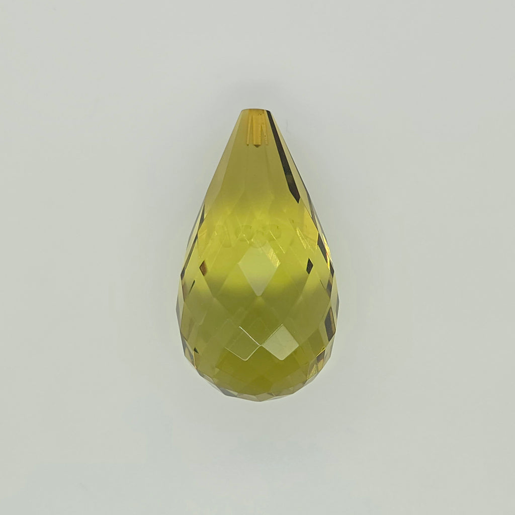 A faceted teardrop-shaped bead in a translucent yellow-green color, shown against a plain light gray background.