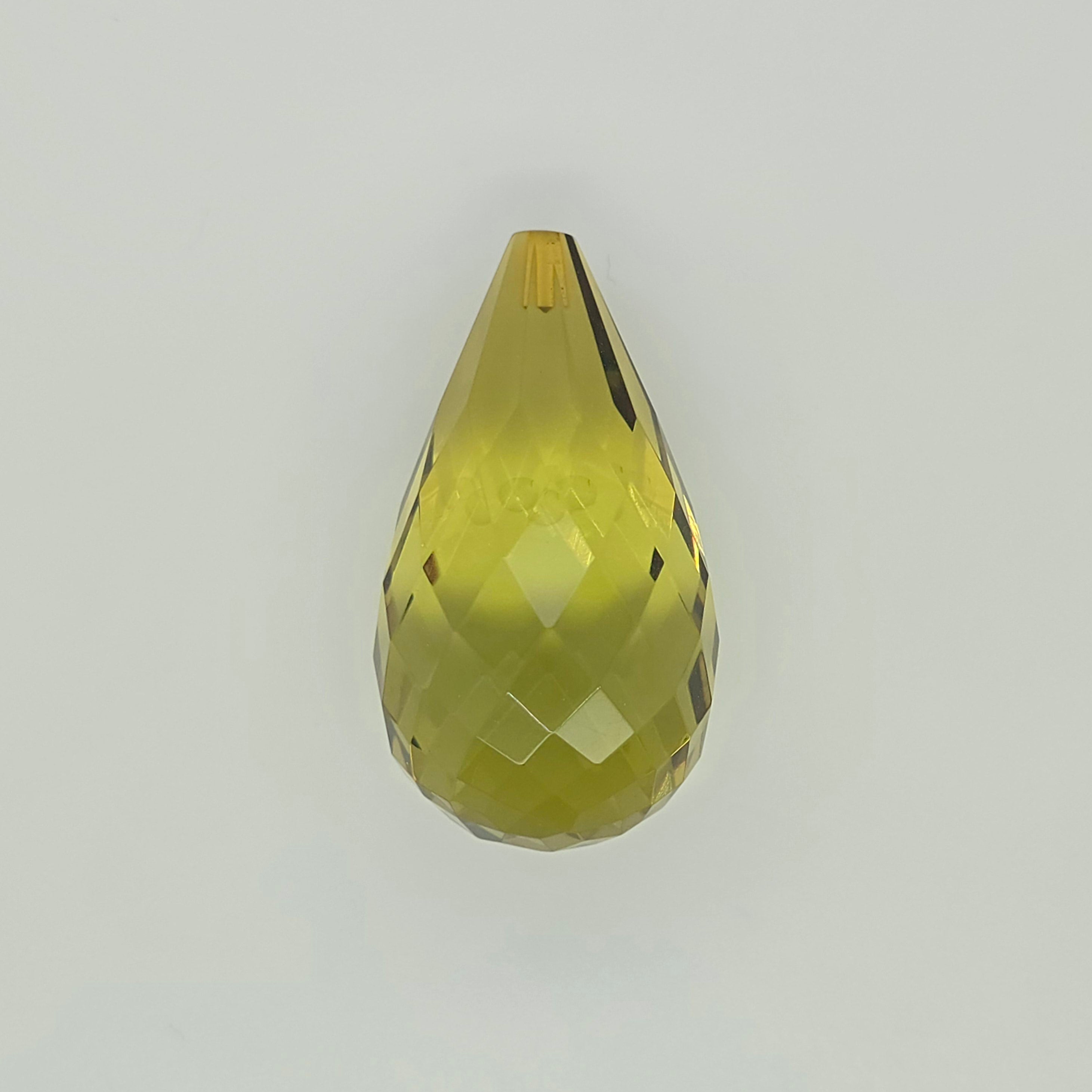 A faceted teardrop-shaped bead in a translucent yellow-green color, shown against a plain light gray background.