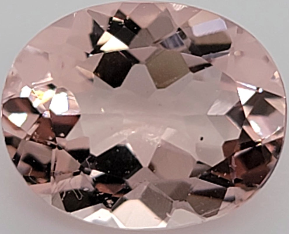 Oval transparent pink gemstone on white background