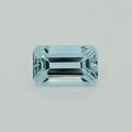 A light blue emerald-cut gemstone with a brilliant faceted finish, centered on a clean, light gray background.
