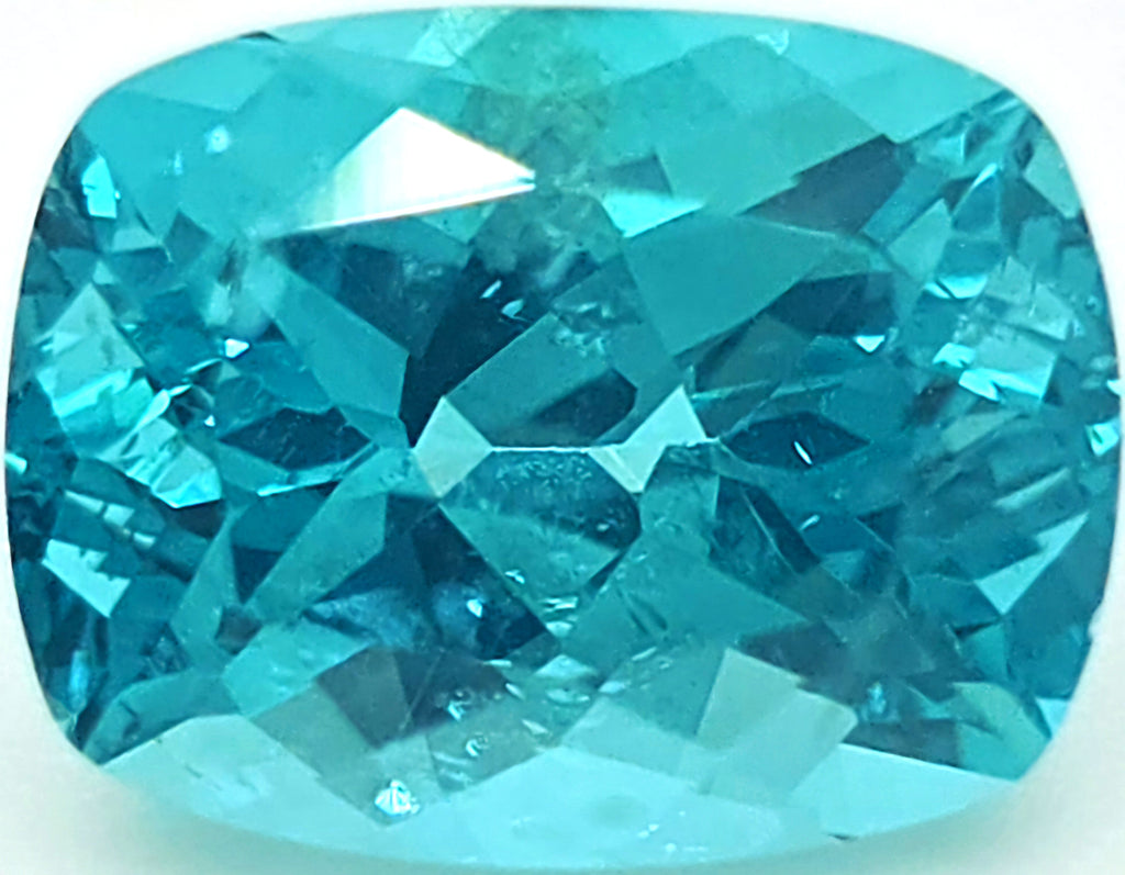 A cushion-cut, faceted blue gemstone, shown on a plain white background.