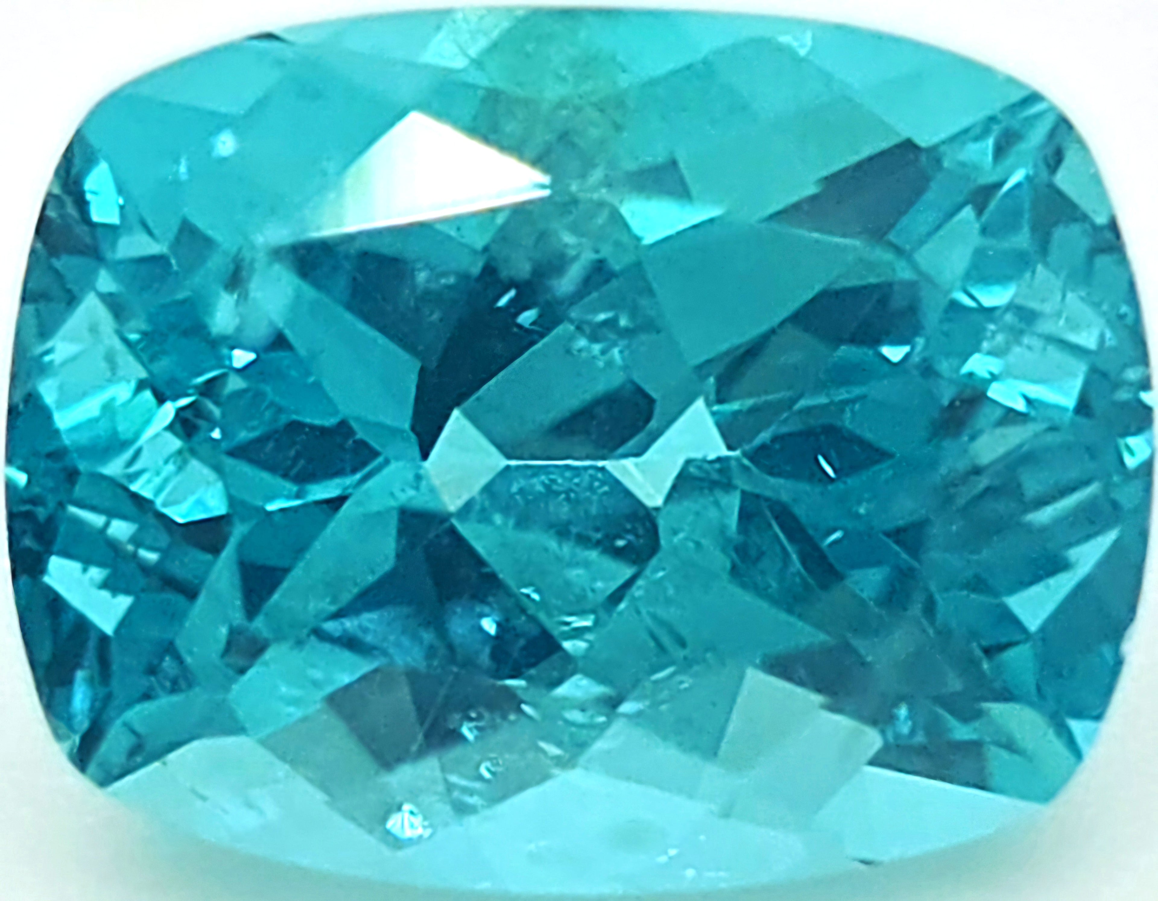 A cushion-cut, faceted blue gemstone, shown on a plain white background.