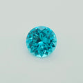 A round brilliant-cut greenish blue gemstone, centered on a clean, light gray background.