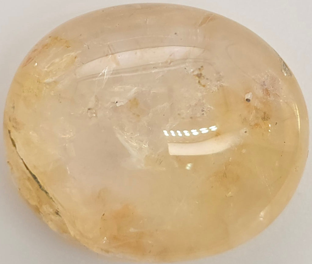 Yellow sapphire cabochon on a white background