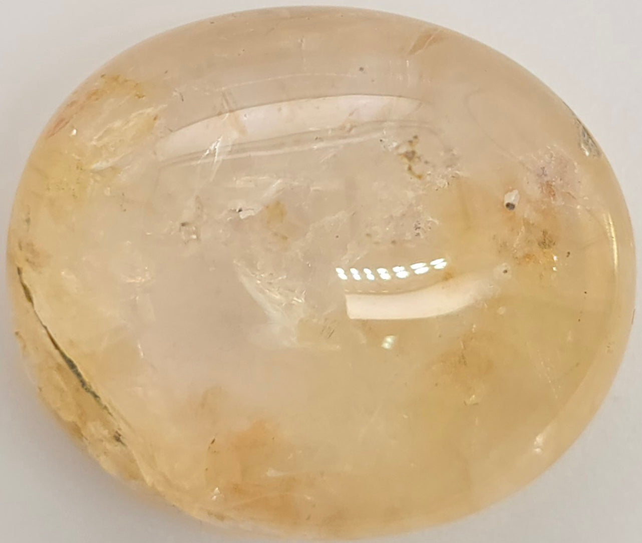 Yellow sapphire cabochon on a white background