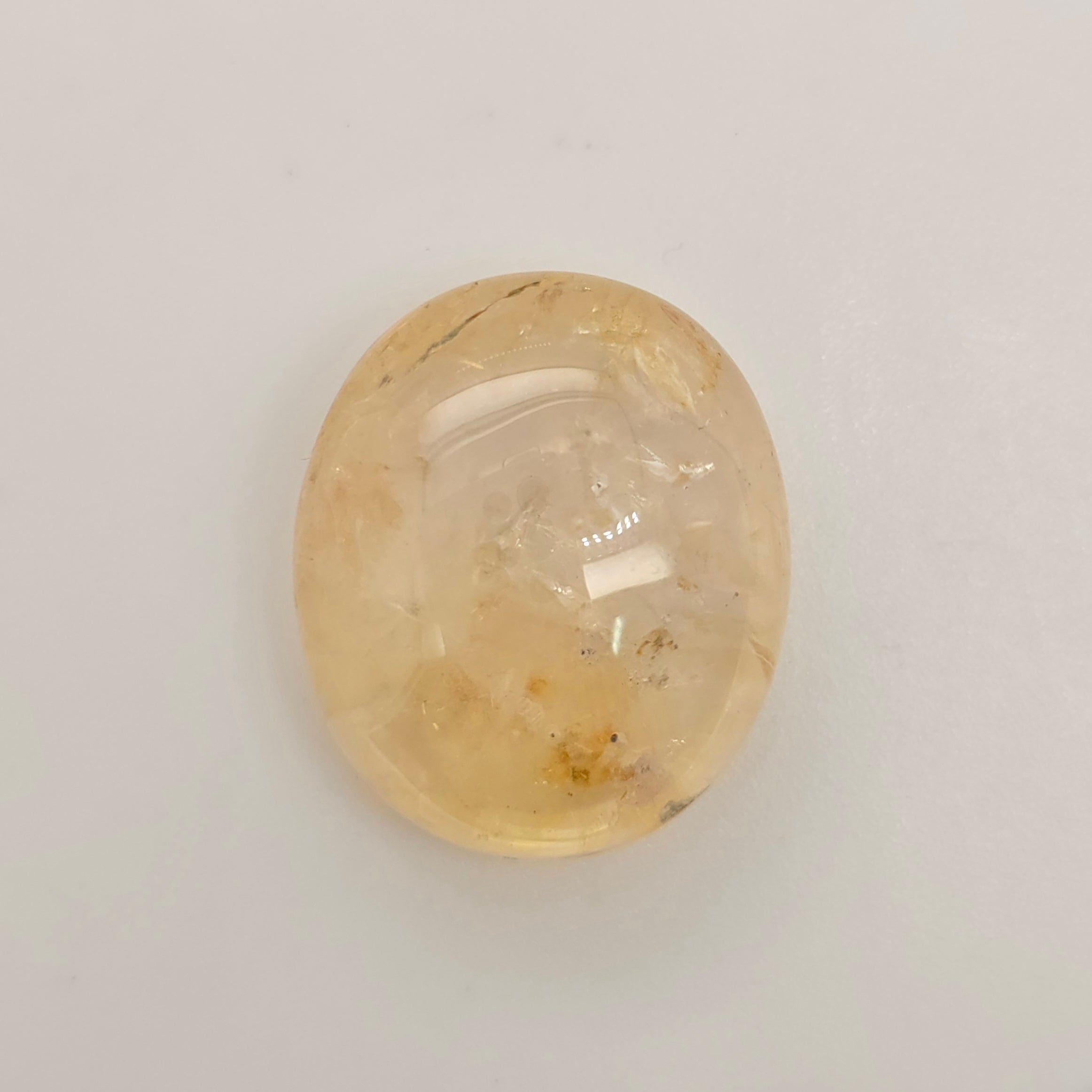 Oval-shaped Sapphire stone on a light gray background