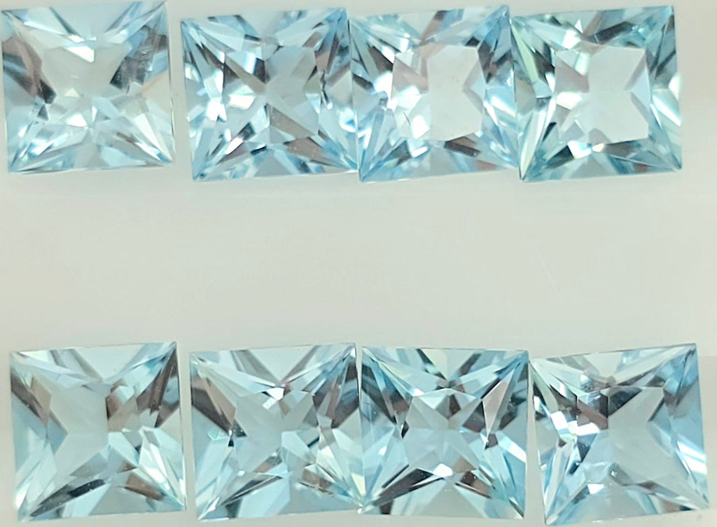 Eight light blue square faceted gemstones arranged in two rows on a plain white background.