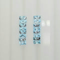 Eight square faceted light blue gemstones arranged in two vertical columns against a plain white background