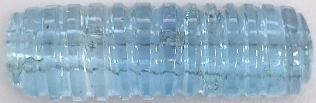 A light blue ribbed gemstone in a horizontal orientation shown against a plain white background.