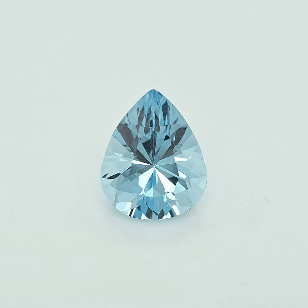 A light blue pear shaped faceted gemstone against a plain white background