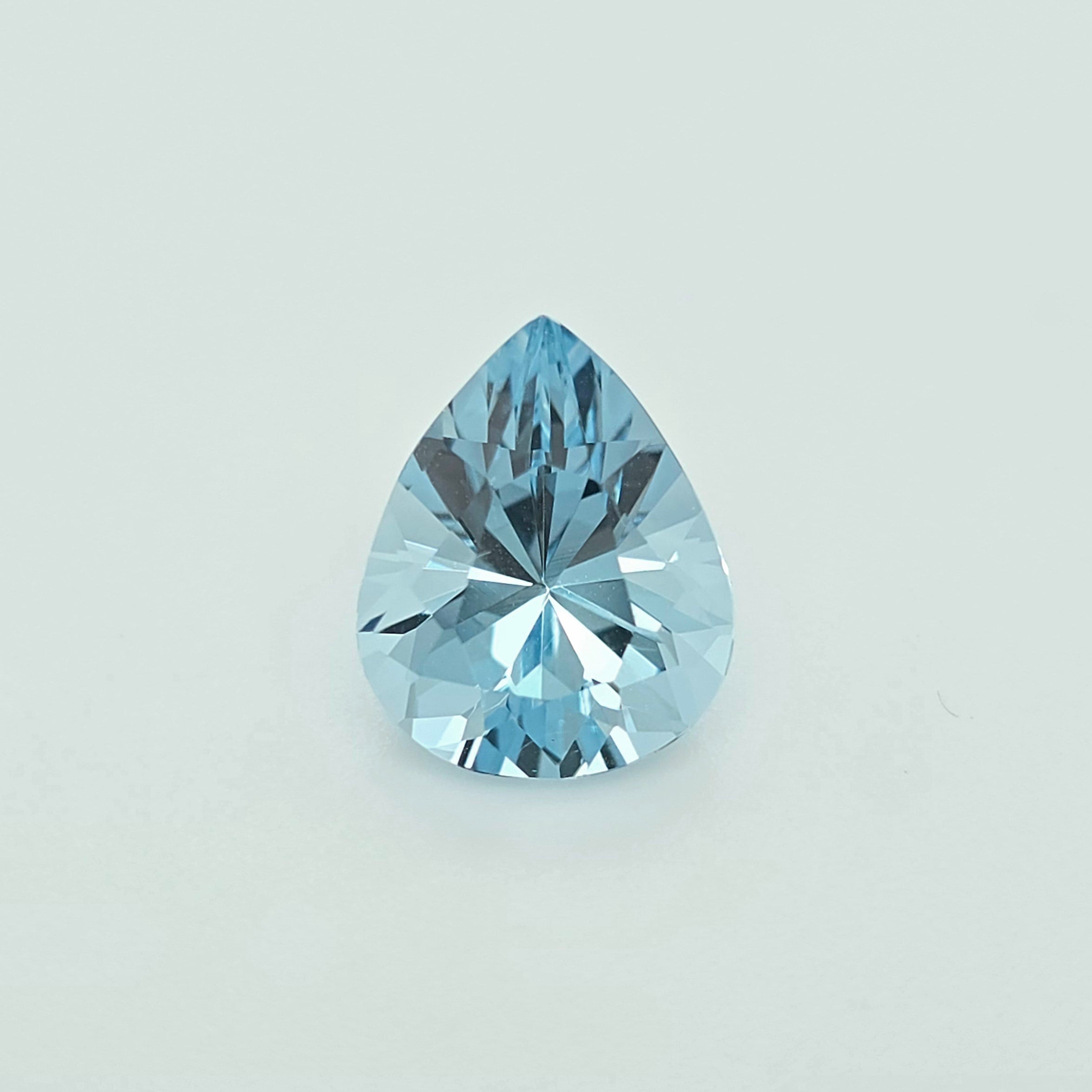 A light blue pear shaped faceted gemstone against a plain white background
