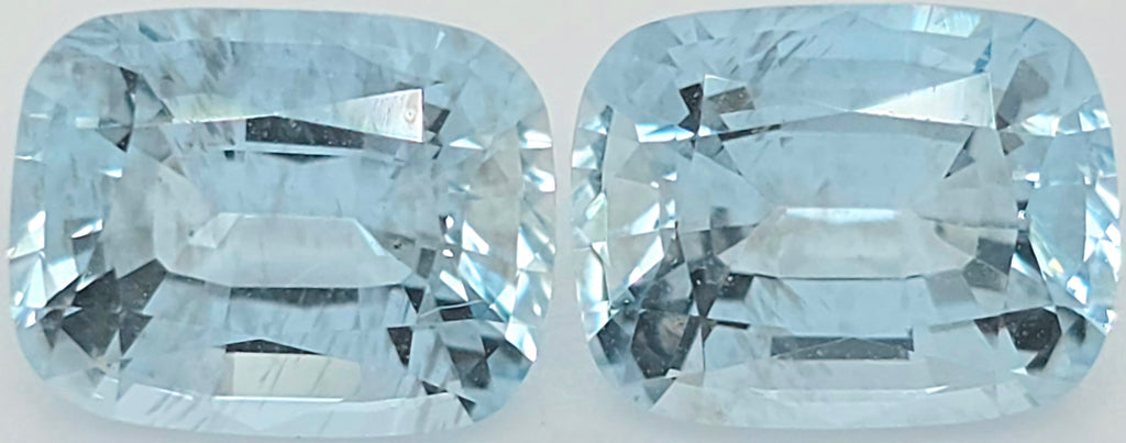 Two light blue cushion-cut gemstones shown side by side on a plain white background.