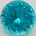 A round brilliant-cut turquoise gemstone showing vibrant blue-green facets against a plain light background.