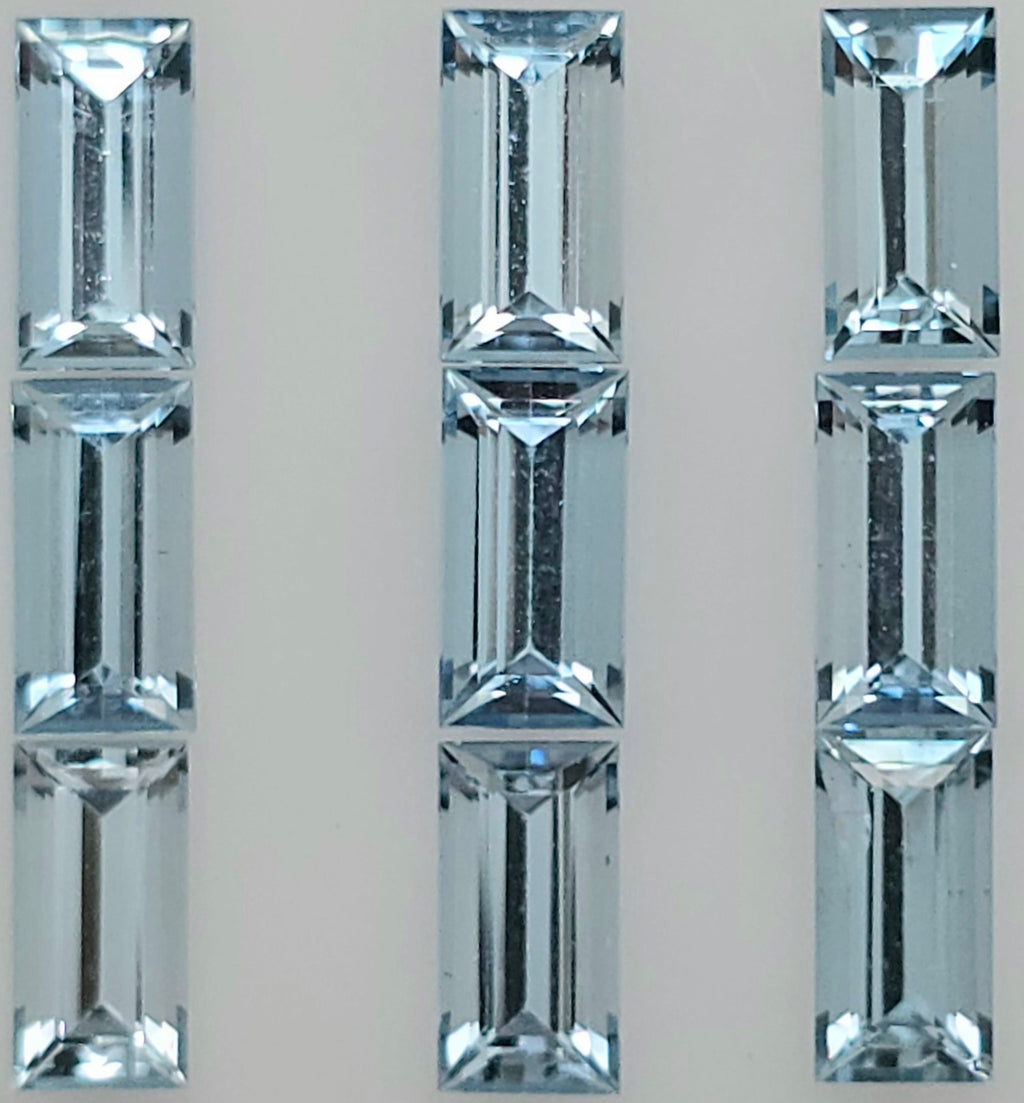 Close-up image of nine rectangular light blue faceted stones arranged into three columns on a plain white background