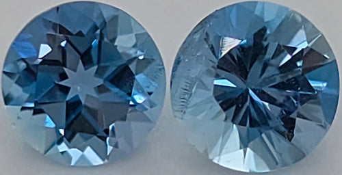 Two round brilliant-cut blue gemstones shown side by side on a plain light background.