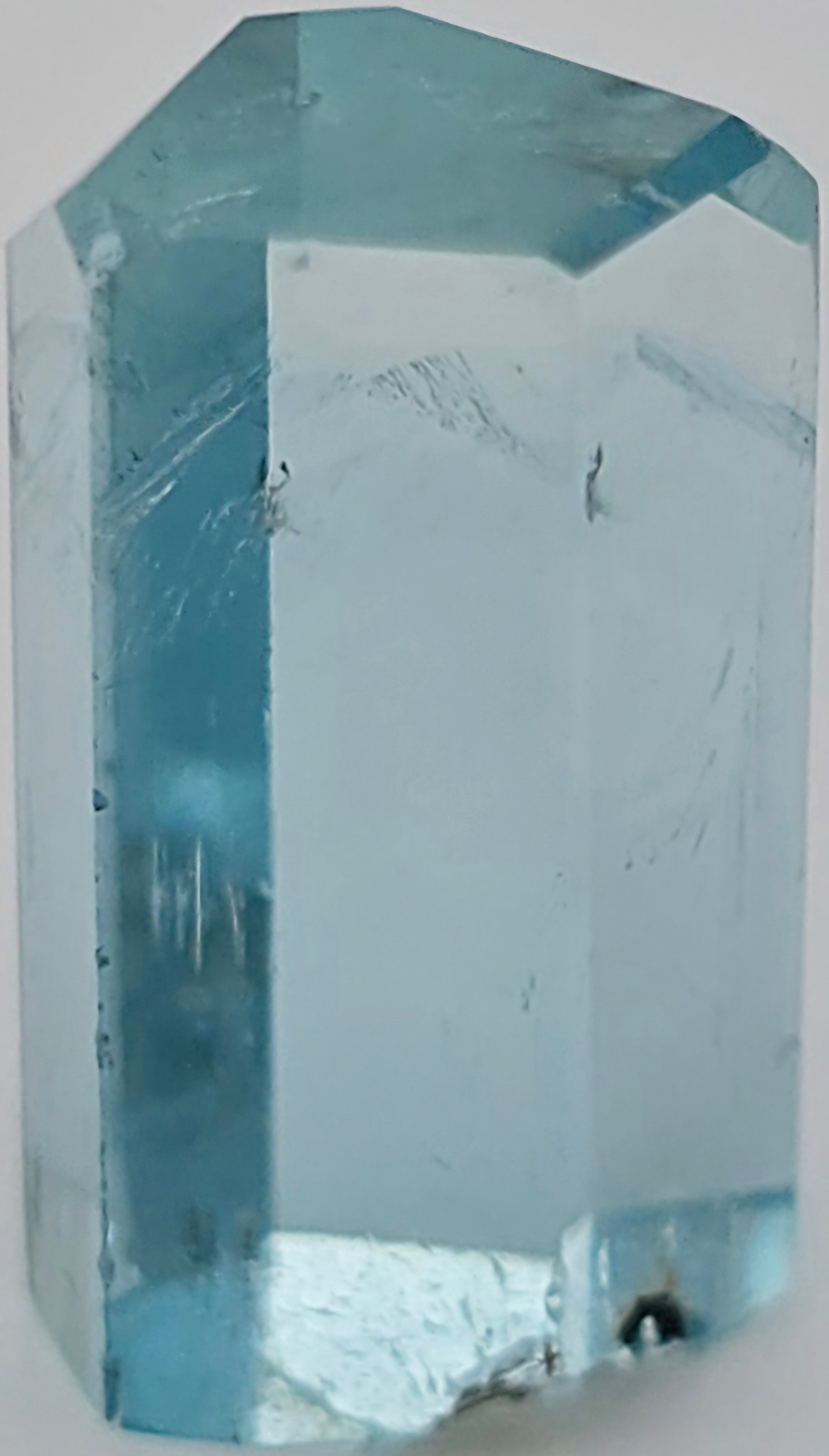 A light blue crystal cut with a hexagonal shape, shown close-up against a plain light background.