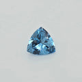 A single faceted triangular blue gemstone, centered on a plain light gray background.