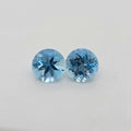 Two round blue gemstones displayed side-by-side on a plain light gray background.