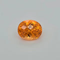 An oval-cut orange gemstone with a faceted, diamond-cut pattern, centered on a light gray background.