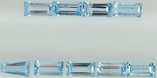 Nine light blue rectangular baguette-cut gemstones arranged in two rows on a plain white background.