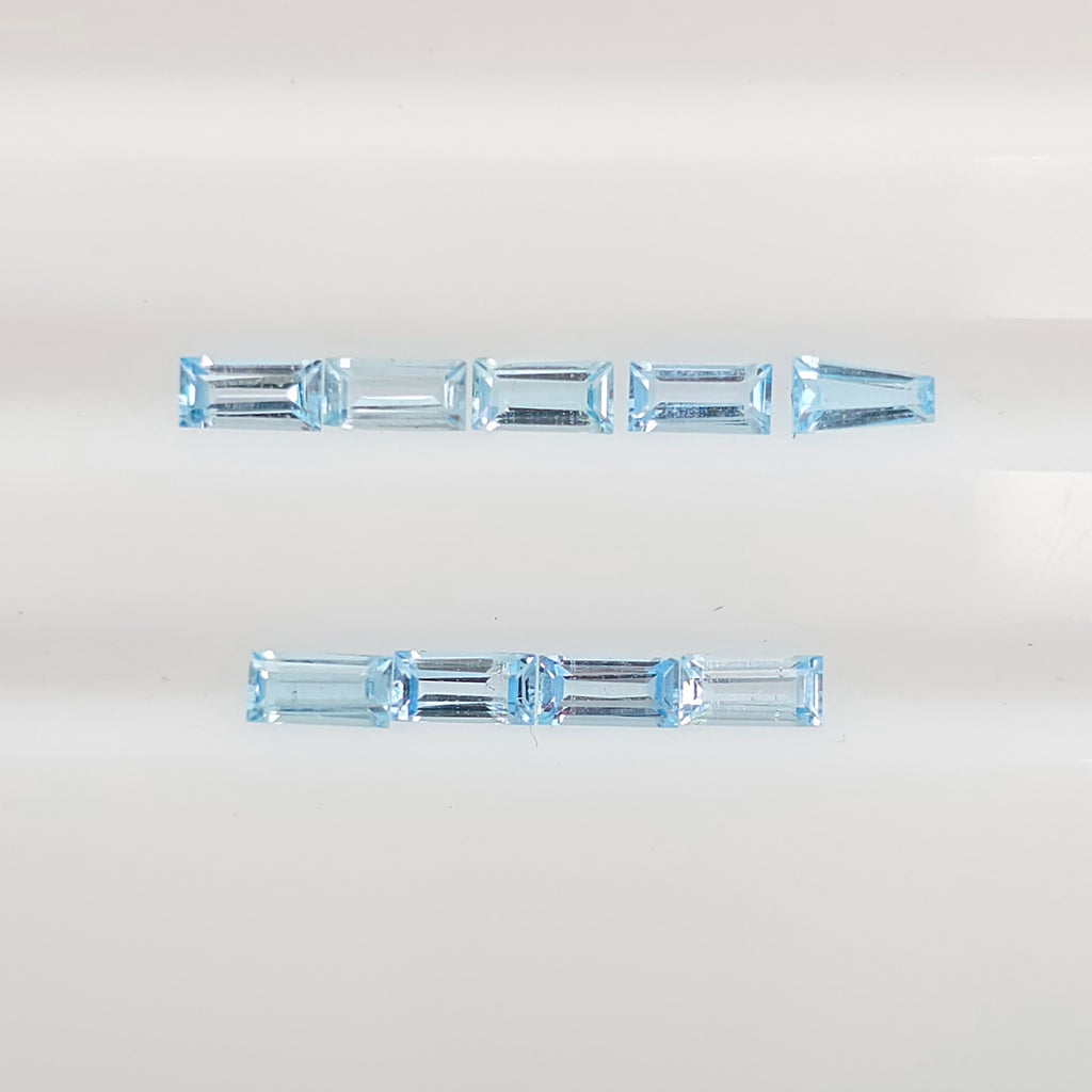 Nine baguette cut gemstones arranged in two horizontal rows on a plain white background