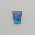 A trapezoid shaped gemstone with a blue to turquoise gradient, displayed on a neutral light gray background.