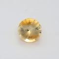 A single round-cut yellow gemstone with a faceted, multi-hole design, shown on a plain white background.