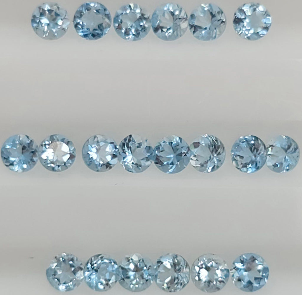 Twenty round-cut light blue gemstones arranged in three horizontal rows on a plain light background.