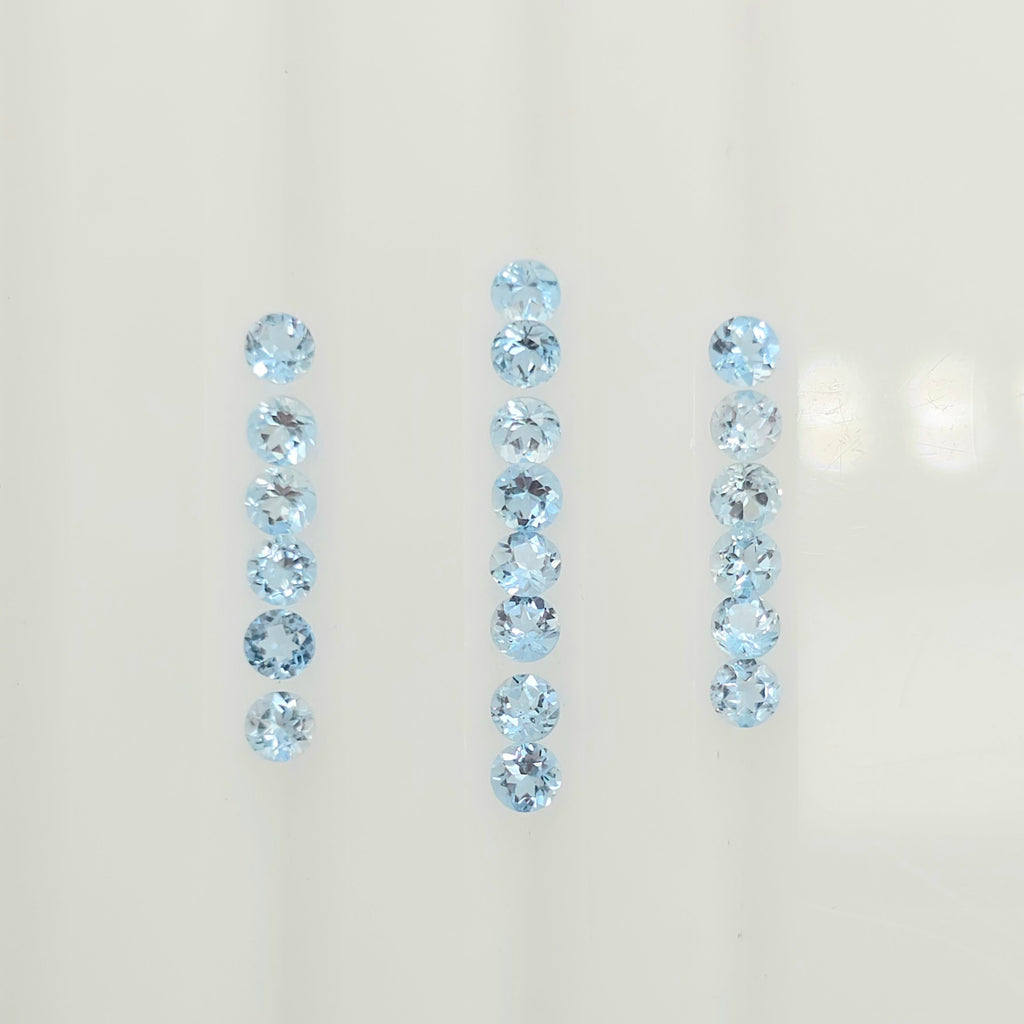 Three vertical rows of light blue faceted round gemstones on a plain off-white background.