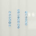 Three vertical rows of light blue faceted round gemstones on a plain off-white background.