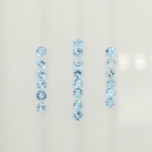 Three vertical rows of light blue faceted round gemstones on a plain off-white background.